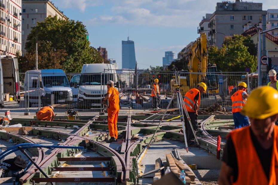 Zdjęcie przedstawia grupę robotników budujących układ torów umożliwiający ruch tramwajów we wszystkich kierunkach u zbiegu Grójeckiej, Bitwy Warszawskiej 1920 roku i Banacha