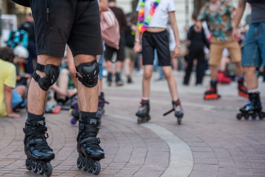 Zdjęcie przedstawia nogi grupy rolkarzy, którzy zgromadzili się przed pomnikiem Mikołaja Kopernika, by wziąć udział w przejeździe cyklu Nightskating Warszwa