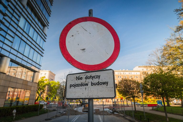 Zdjęcie przedstawia znak drogowy B-1 zakaz ruchu. Pod nim tabliczka z napisem: nie dotyczy pojazdów budowy.