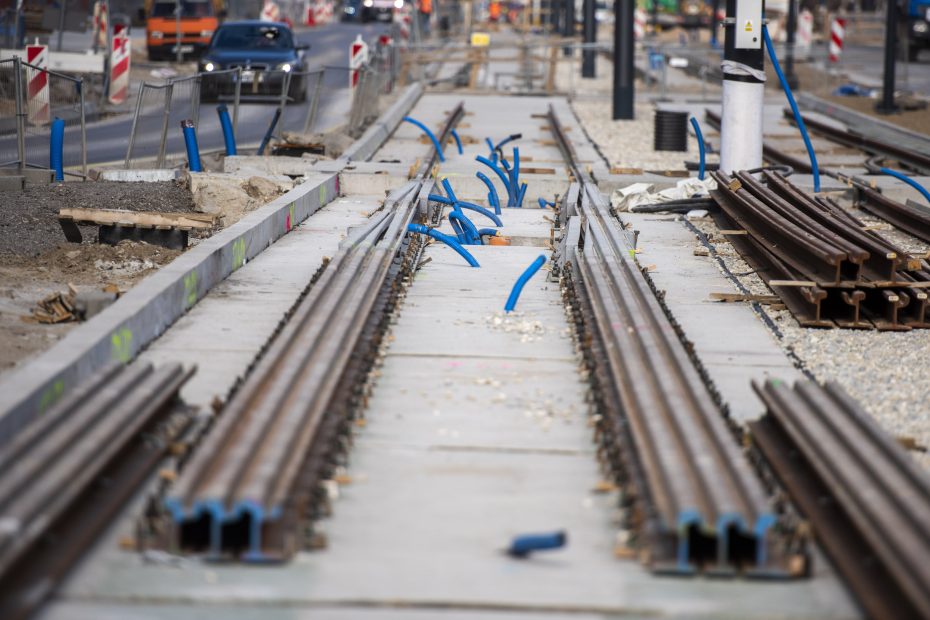 Zdjęcie przedstawia budowę torowiska tramwajowego. Na Betonowym podłożu leżą stalowe szyny.